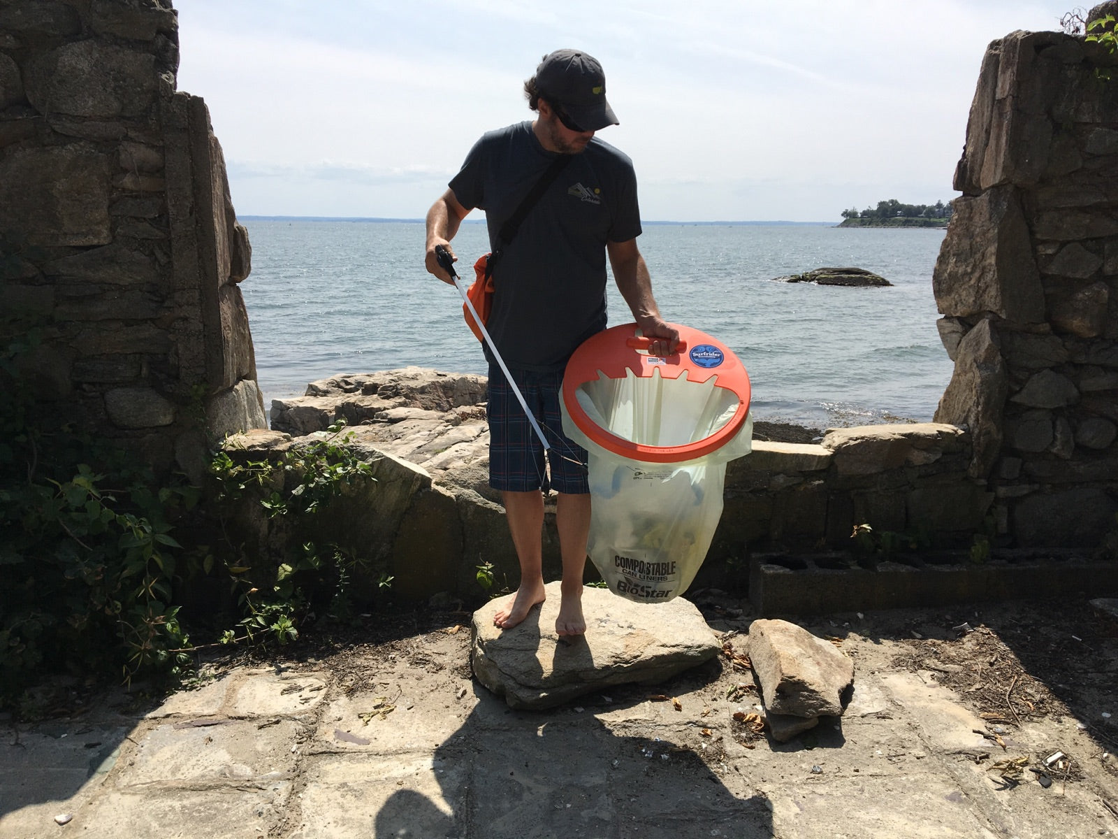 guy picking up trash at beach