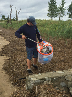 guy picking up trash at beach