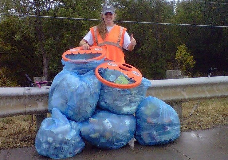 girl standing next to bags of garbage